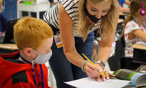 teacher works with student